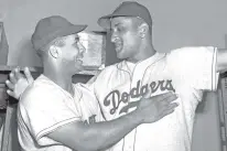  ?? MATTY ZIMMERN/ASSOCIATED PRESS FILE PHOTO ?? Brooklyn Dodgers catcher Roy Campanella, left, congratula­tes his battery mate, Don Newcombe, in 1949 in the dressing room at the Polo Grounds in New York.