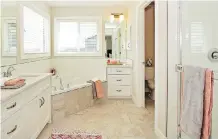  ??  ?? The ensuite has oodles of natural light and cupboard space along with a large soaker tub, shower stall and dual vanities.