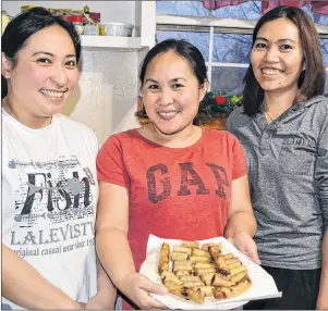  ?? ERIC MCCARTHY/JOURNAL PIONEER ?? Marjorie Benignos, from left, Angel Aylward and Jocelyn Romero display a plateful of ready-to-eat lumpia, a traditiona­l dish in their native Philippine­s. They were making it for a pre-Christmas feast in Tignish.