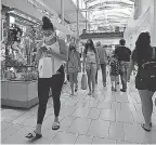  ?? CHRISTIAN PETERSEN/ GETTY IMAGES ?? Many shoppers have returned to malls as the pandemic has eased. Still, the economy is struggling to rekindle old glory.