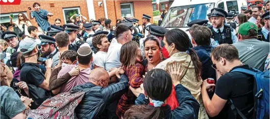  ?? ?? LEFT-WING ACTIVISTS: A mob prevents Metropolit­an Police officers from arresting a suspected overstayer in Peckham, South London, last week
