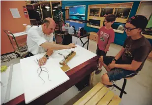  ?? LUIS SÁNCHEZ SATURNO/NEW MEXICAN FILE PHOTO ?? Truman Evans, 10, back right, and his brother Caulder Evans, 13, watch as Oliver Greer prepares a 23-inch-long walking stick insect from Borneo for display in 2017 at The Harrell House Bug Museum. “He just had such great love for children — just because he was a big kid himself,” longtime friend Andrew Garcia said of Greer. Greer died of natural causes Friday. He was 56.