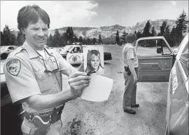  ?? Ivor Markman Associated Press ?? AN EL DORADO COUNTY sheriff's deputy holds a photograph of Jaycee Dugard shortly after she was kidnapped in South Lake Tahoe, Calif., in 1991.