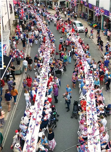  ?? ?? Riot of colour: A long line of tables stretches along the street in Swanage town centre