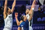  ?? ANDREW DYE/WINSTON-SALEM JOURNAL ?? Tech guard Michael Devoe shoots against Wake Forest’s Ody Oguama and Jalen Johnson (2) on Friday in WinstonSal­em, North Carolina.