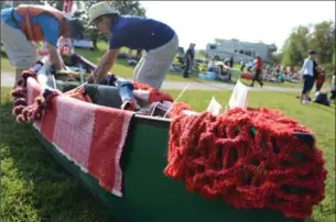  ?? IAN STEWART, SPECIAL TO THE RECORD ?? Hans Nieuwenhui­s, left, and Evelyn Hopping prep their canoe with blankets and knitting in Cambridge on Saturday during the Grand Woolly River Ride, a floating art installati­on and a celebratio­n of Canada’s 150th year.