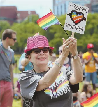  ?? STAFF PHOTOS BY ANGELA ROWLINGS ?? PRIDE: Liz Nania of Roslindale cheers during the ‘Stronger Together’ rally at Boston Common yesterday. Above left, Nigel Simon of Dorchester attends the event, which honored the victims of the attack at Pulse nightclub in Orlando, Fla., one year ago.