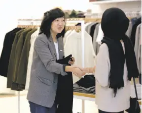  ??  ?? Everlane Lab’s Megan Han, above, greets a customer. Physical stores can help online retailers such as Everlane with advertisin­g and branding.