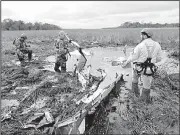  ?? AP/ROQUE GONZALEZ VERA ?? Rescue workers search at the crash site Thursday of a twinengine Beechcraft Baron in Ayolas, Paraguay. Paraguay’s agricultur­e minister and three other people were killed when the plane went down in a marshy area shortly after taking off Wednesday night.