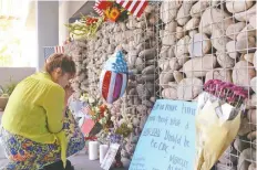  ??  ?? Una mujer presenta sus respetos a la memoria del senador John McCain, ante el altar improvisad­o en sus oficinas de Phoenix, Arizona.