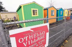  ?? ELAINE THOMPSON/ASSOCIATED PRESS ?? A line of tiny houses stand with their backs to the adjacent street at a homeless encampment in Seattle.