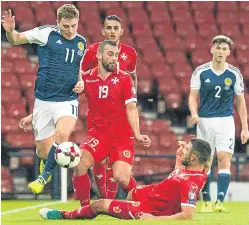  ??  ?? James Forrest tries to find a way past Malta’s Joseph Zerafa and Andre Schembri.