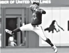  ?? Associated Press ?? ■ Toronto Blue Jays second baseman Yangervis Solarte makes a leaping throw to get Baltimore Orioles Mark Trumbo out at first in the second inning of a baseball game Saturday in Toronto.