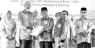  ??  ?? ROSLI (empat dari kanan) bersama isteri menerima sijil Anugerah Khas Pasangan yang disampaika­n oleh Juhar.