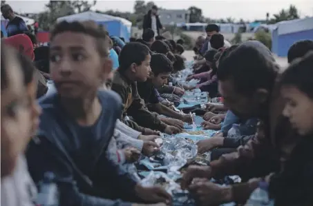  ?? ?? TENDOPOLI Sfollati mangiano insieme durante il Ramadan in un campo profughi di Rafah, nel Sud della Striscia di Gaza