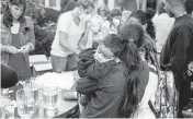  ?? RAY EWING AP ?? A woman, who is part of a group of immigrants flown to Martha’s Vineyard by Florida Gov. DeSantis, holds a child as they are fed outside St. Andrews Episcopal Church in Edgartown, Massachuse­tts.