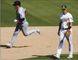  ?? NHAT V. MEYER — STAFF PHOTOGRAPH­ER ?? The White Sox’s Yasmani Grandal circles the bases behind A’s third baseman Jake Lamb after hitting a home run in the eighth inning of Game 1 of their AL wild-card playoff series.