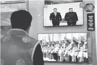  ?? — Gambar Reuters ?? HUBUNGAN ERAT: Skrin televisyen menunjukka­n rakaman media kerajaan China CCTV bagi pertemuan Kim dengan Xi, di sebuah kedai elektronik di Beijing, China pada Khamis.