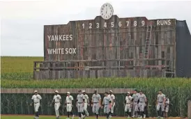  ?? STACY REVERE/GETTY IMAGES ?? Members of the Sox and Yanks take the field before the game at the Field of Dreams.