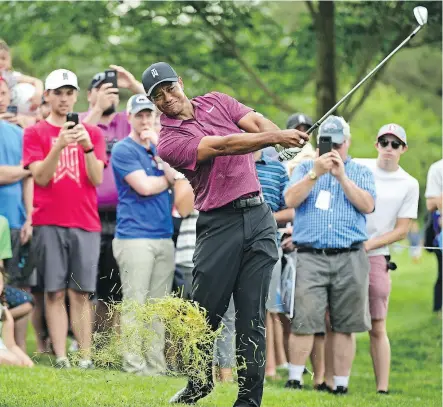  ?? DAVID DERMER / THE ASSOCIATED PRESS ?? Tiger Woods, swinging out of the rough on Wednesday in the pro-am for the Memorial golf tournament, has gone 10 years since winning his last major.