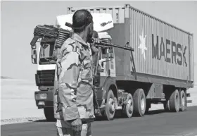  ?? RAHMATULLA­H NAIKZAD/AP FILE ?? A private security contractor watches a NATO supply truck in the province of Ghazni, Afghanista­n, in 2010. The role of military contractor­s has come under scrutiny.