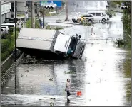  ?? AP/KOTA ENDO ?? Vehicles and debris litter streets in Osaka, western Japan, after Tuesday’s typhoon. The storm disrupted travel and knocked out electricit­y in six prefecture­s.