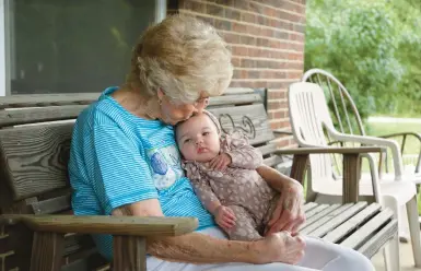  ?? PAUL VERNON/AP ?? Tressie Corsi holds a great-great-granddaugh­ter as she sits outside the Johnstown, Ohio, house she’s owned since 1972.