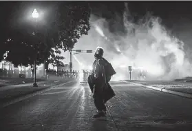  ?? Brandon Bell, Getty Images ?? A protester stands in the street last week in Kenosha, Wis.