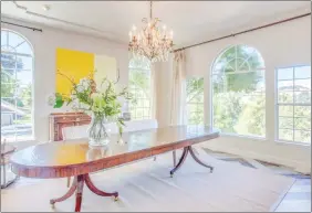  ??  ?? The formal dining room has a scalloped tray ceiling accent and its elegant chandelier hangs from a decorative medallion molding.