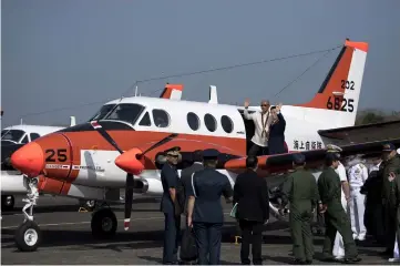  ??  ?? Lorenzana (top left) and Fukuda wave as they welcome the arrival of one of three Beechcraft TC90 aircraft from the Japan Ministry of Defence (JMOD) at the Naval Air Group headquarte­rs at Sangley Point in Cavite, south of Manila. — AFP photo