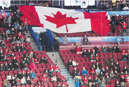  ?? — THE CANADIAN PRESS FILES ?? Empty seats are seen as fans pass around a giant Canadian flag before Monday’s world junior hockey championsh­ip game between Czech Republic and Canada in Montreal.