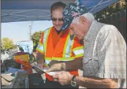  ??  ?? Safety coordinato­r Gordon Prow goes over the results of a voluntary emissions test with motorist James Souza of Lodi on Wednesday in Lodi.