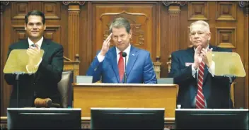  ?? ASSOCIATED PRESS ?? In this Jan. 16 file photo, Gov. Brian Kemp, (center) is flanked by House Speaker David Ralston, R-Blue Ridge (right) and Lt. Gov. Geoff Duncan as he salutes former U.S. Senator Johnny Isakson, R-Ga., during the State of the State address before a joint session of the Georgia General Assembly in Atlanta.