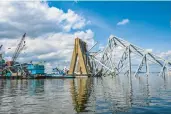  ?? JERRY JACKSON/STAFF ?? Girders of the Francis Scott Key Bridge stick out of the water around the remaining structural support pier.