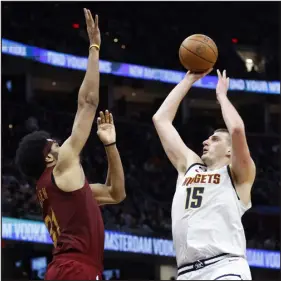  ?? RON SCHWANE — THE ASSOCIATED PRESS ?? Denver center Nikola Jokic shoots against Cleveland center Jarrett Allen in the second half on Thursday night in Cleveland.