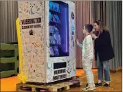  ?? PHOTO COURTESY OF FOUNDATION FOR BOYERTOWN EDUCATION ?? A Washington Elementary student selects the first book from the book vending machine presented to the school by the Foundation for Boyertown Education.