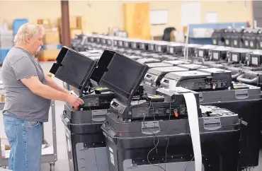  ?? ADOLPHE PIERRE-LOUIS/JOURNAL ?? Robert Stowell tests a voting machine for visually and hearing impaired voters at the Bernalillo County Voting Warehouse in preparatio­n for the start of early voting today.