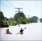  ?? PATRICK HAMILTON/AFP ?? Kayakers paddle on the flooded Logan River, caused by Cyclone Debbie, as it flows over the Mt Lindesay Highway in Waterford West near Brisbane on Saturday.