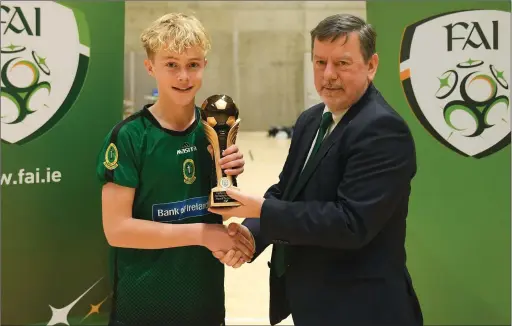  ??  ?? Odhran Ferris of Mercy Mounthawk School, Tralee, is presented with the player of the tournament award by FAI president Donal Conway after the PostPrimar­y Schools National Futsal Finals at Waterford IT Sports Arena in Waterford. Photo by Sportsfile