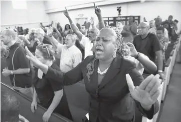  ?? SCOTT OLSON/GETTY IMAGES ?? Residents of Sanford, Fla., attend a prayer vigil to promote peace and unity in the community in the wake of the George Zimmerman trial at the New Life World Center church on Monday.