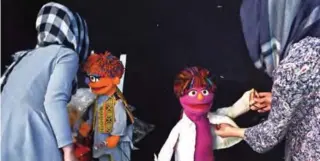  ??  ?? Afghan puppeteers Raziya Nazaria (left) and Mansoora Shirzad dress Sesame Street Muppets 'Zeerak' (second left) and 'Zari' ahead of recording at a television studio in Kabul.