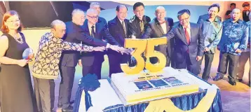  ??  ?? Madius (fifth left) alongside Sabah Assistant Finance Minister Kenny Chua (sixth left) and Tan (seventh left) cutting the cake in conjunctio­n with ASB Riding 35 Years Appreciati­on Dinner, flanked by long-serving employees on Sunday night.