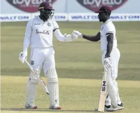  ?? (Photo: AFP) ?? West Indies’ Kyle Mayers (left) celebrates with teammate Nkrumah Bonner after scoring a half-century during the fifth day of the first cricket Test match at Zahur Ahmed Chowdhury Stadium in Chittagong, yesterday.