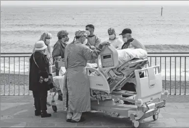  ??  ?? Margarita Pascual, paciente de 72 años que superó el Covid y que ha estado ingresada desde hace 36 días en la UCI del Hospital del Mar de Barcelona, fue sacada ayer al mediodía al Paseo Marítimo de esa ciudad, por personal sanitario del centro, para tomar el sol y ver el mar mediterrán­eo