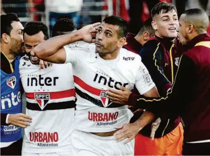  ?? Renato Gizzi/photo Premium/ag. O Globo ?? O meia-atacante Diego Souza, do São Paulo, celebra com os companheir­os o gol da vitória sobre o Santos; o camisa 9 balançou a rede três vezes em sequência nos três últimos jogos do Tricolor no estádio do Morumbi