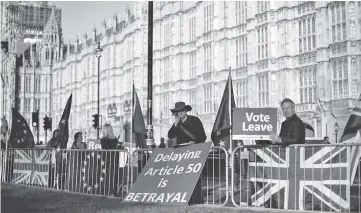  ??  ?? Pro-Brexit activists hold placards as they demonstrat­e outside of the Houses of Parliament in London. — AFP photo