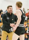  ?? ?? South River wrestling coach John Klessinger congratula­tes Sam Ditmars after Ditmars earned his 100th career win at Saturday’s Class 4A/3A East Region wrestling tournament.