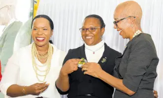  ?? IAN ALLEN/PHOTOGRAPH­ER ?? Fayval Williams (right), minister of education and youth (MOEY) and Kasan Troupe (left), permanent secretary in the MOEY, pins a badge for mentorship on Venessa Russell (centre) from Godfrey Stewart High school, and regional officer, Jamaica Teaching Council (JTC), Region IV. Occasion was the Jamaica Teaching Councils Beginning Teachers Synergy Conference under the theme: Empowering Tomorrow’s Leaders Embracing Transforma­tion in Education which was held at the Mico University last Friday.