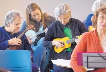  ?? MARLA BROSE/JOURNAL ?? K.C. Cotkin, from left, Jen Graham and Su Hudson take part in a recent ukulele jam session at the Juan Tabo Library.