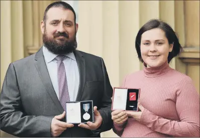  ??  ?? John Moore with his Queen’s Galantry Medal and Theresa Cosgrove who received the Queen’s Commendati­on for Bravery.